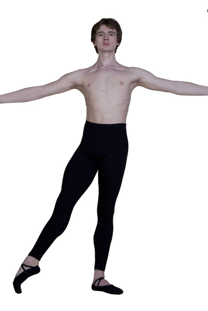 Ein Balletttänzer, der Sanshas „Männerstrumpfhosen-Leggings ohne Fuß“ und Pantoffeln trägt, posiert mit ausgestreckten Armen und einem angehobenen Bein vor einem schlichten weißen Hintergrund. Die Marke Sansha ist in der oberen rechten Ecke sichtbar.