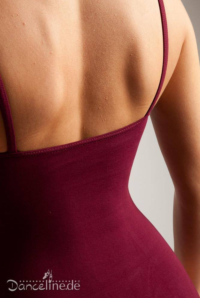 Eine Nahaufnahme des Rückens einer Person, die einen ärmellosen, taillierten Ballettanzug Bloch L3227 Seam in Braun mit dünnen Trägern und Prinzess-Nähten trägt. Der Fokus liegt auf dem Rücken- und Schulterbereich. In der unteren linken Ecke des Bildes ist der Text „Danceline.de“ zu sehen.