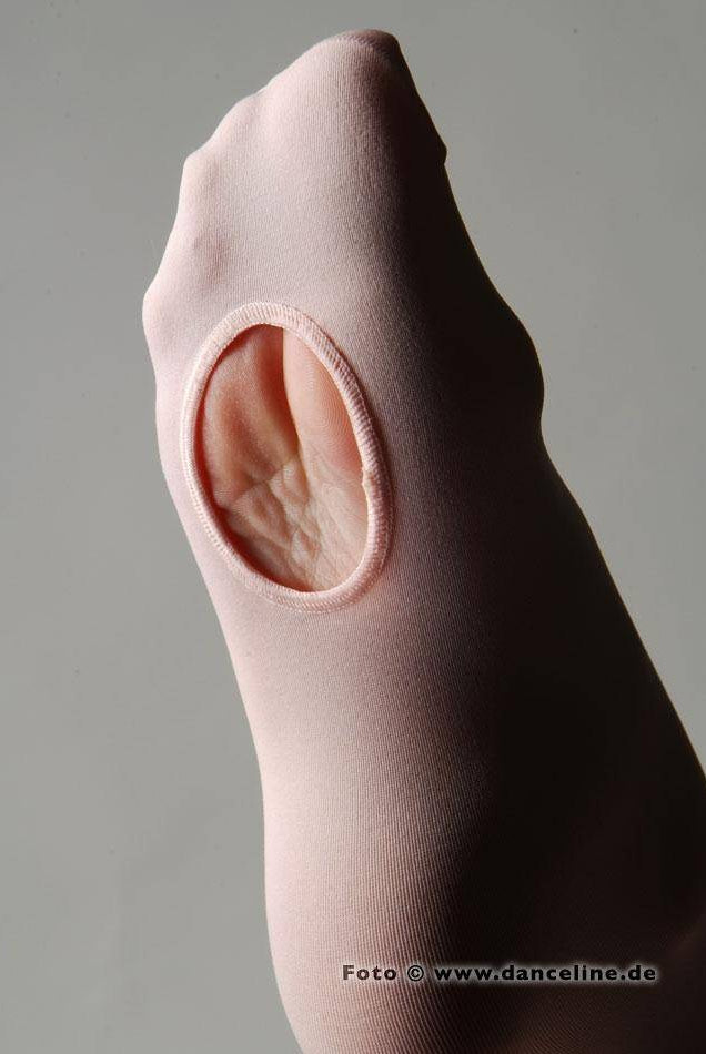 Nahaufnahme eines Fußes, der eine pfirsichfarbene Capezio Ballettstrumpfhose 1818 B-Tight mit einer ovalen Öffnung am Fußgewölbe trägt, die einen Teil der Sohle freigibt. Der Hintergrund ist schlicht und neutral. In der unteren rechten Ecke ist teilweise eine URL „www.danceline.de“ sichtbar.