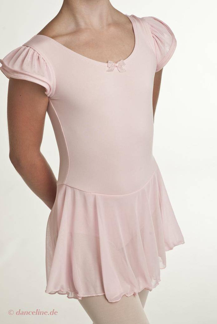 Eine Person trägt einen blassrosa Kinder-Ballettanzug Capezio 11882C Puff Sleeve von Capezio mit einer kleinen Schleife am Ausschnitt und einem angenähten Rock. Das zum Tanzen entworfene Outfit ist vor einem schlichten weißen Hintergrund fotografiert, wobei das Gesicht der Person nicht sichtbar ist.