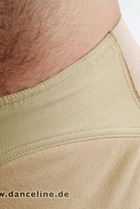 Nahaufnahme eines Mannes, der den Tanzslip Capezio Suspensorium (Modell 5930 SusiB) in Beige trägt. Der Bund und der glatte Stoff sind deutlich zu erkennen, ebenso Teile des Unterleibs und des Beinbereichs der Person. Das Foto enthält in der unteren linken Ecke ein Wasserzeichen mit dem Text „Foto © www.danceline.de“.