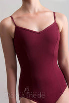 Eine Person trägt einen ärmellosen, burgunderfarbenen Capezio Ballettanzug Capezio CC101 Edisa mit zarten Spaghetti-Trägern. Der Anzug hat ein tailliertes, nahtloses Design. Der Hintergrund ist schlicht und hell. Am unteren Bildrand ist der Text „Danceline.de“ zu sehen.