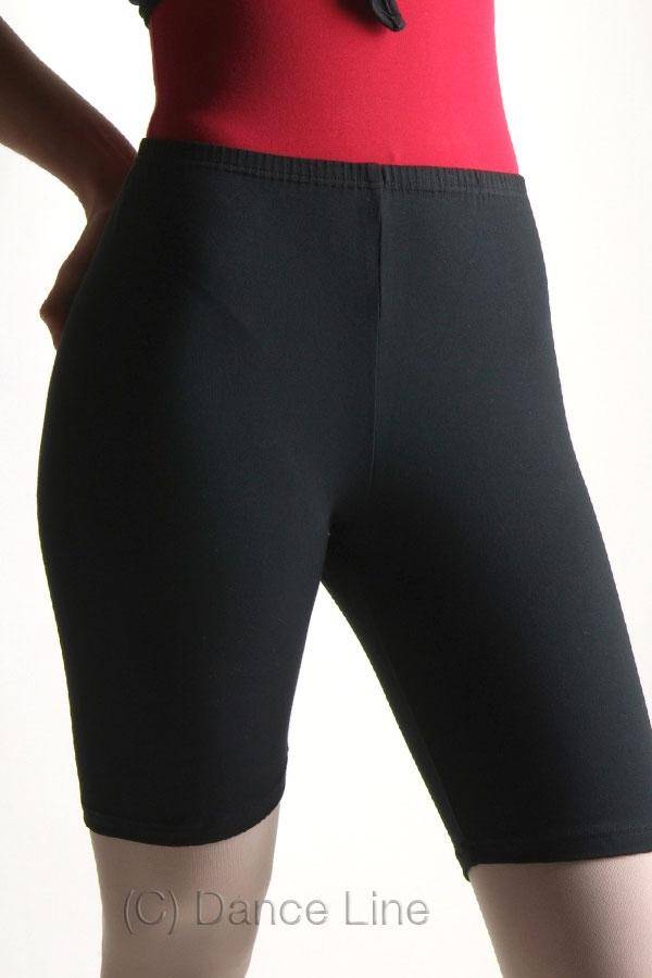 Eine Person trägt ein rotes Oberteil und schwarze Hose Danceries G31 Radler-Shorts und hat die Hände auf den Hüften. Das Bild konzentriert sich auf die Shorts von der Taille bis zur Mitte des Oberschenkels. Unten steht in weißem Text „© Danceries“.