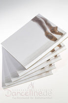 Ein Stapel Broschüren zum Thema Ballett, die das Foto der Beine einer Balletttänzerin in Spitzenschuhen zeigen, präsentiert im schicken Quadratformat. Das Cover der Broschüre ist unten mit einem dezenten Logo versehen und unter dem Bild steht prominent in roter Schrift „Danceline.de Fachversand für Ballettartikel“. Eine perfekte Geschenkidee mit Blöcken Viscosi BM2 Minis von Viscosi!