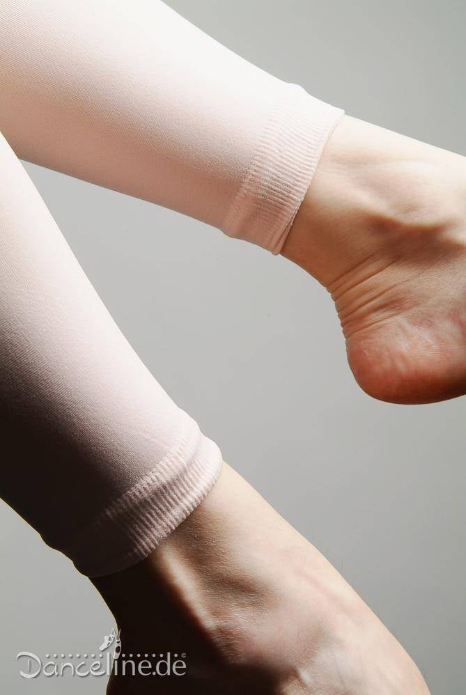 Nahaufnahme von zwei Füßen, die vor einem neutralen Hintergrund eine blassrosa Ballettstrumpfhose Rumpf 106 Sans tragen. Das Bild zeigt die Textur und Passform der sehr dehnbaren Strumpfhose um die Knöchel. Das Logo „Danceline.de“ ist in der unteren linken Ecke sichtbar.