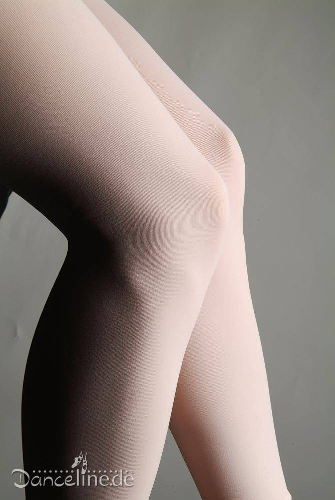 Nahaufnahme von übereinandergeschlagenen Beinen in einer blassrosa Ballettstrumpfhose Rumpf 106 Sans vor einem einfarbigen Hintergrund. Die Textur des Stoffes ist glatt und leicht glänzend, wobei der nahtlose Eindruck betont wird. In der unteren linken Ecke ist das Wort „Danceline.de“ zu sehen.