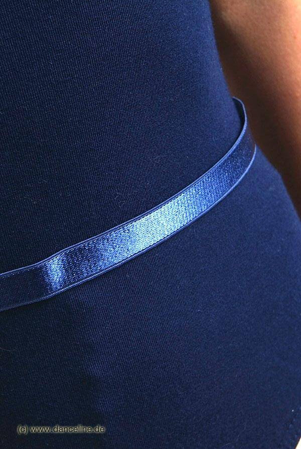 Nahaufnahme einer Person, die das Danceries Taillengummi Rib-Outfit aus dunkelblauem Polyester trägt, kombiniert mit einem passenden glänzenden blauen Gürtel. Der Hintergrund ist unscharf.