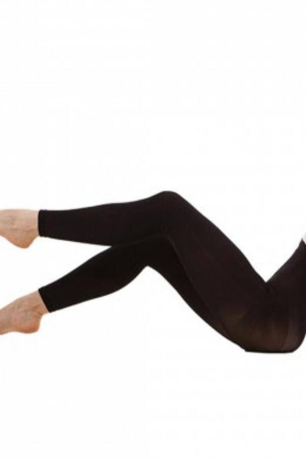 Eine Person, die schwarze Sansha Ballettstrumpfhose T16 Footless Leggings trägt, liegt mit ausgestreckten und leicht angehobenen Beinen, die Zehen sind gestreckt. Der weiße Hintergrund erzeugt einen minimalistischen Look, der die Leggings und die Beinposition betont und das hervorragende Preis-Leistungs-Verhältnis der Sansha-Strumpfhose unterstreicht.