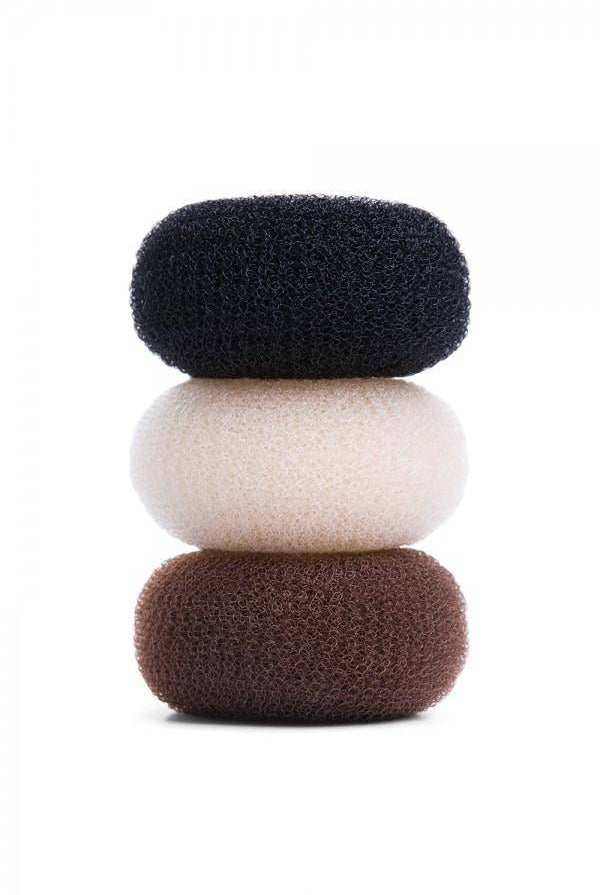Ein Stapel von drei Haar-Donuts von Bloch Duttkissen in verschiedenen Farben. Der obere ist schwarz, der mittlere ist beige und der untere ist braun. Sie sind zylindrisch mit einer hohlen Mitte, bestehen aus einem Netzmaterial, das perfekt symmetrische Haarknoten formt, und sind wiederverwendbar.