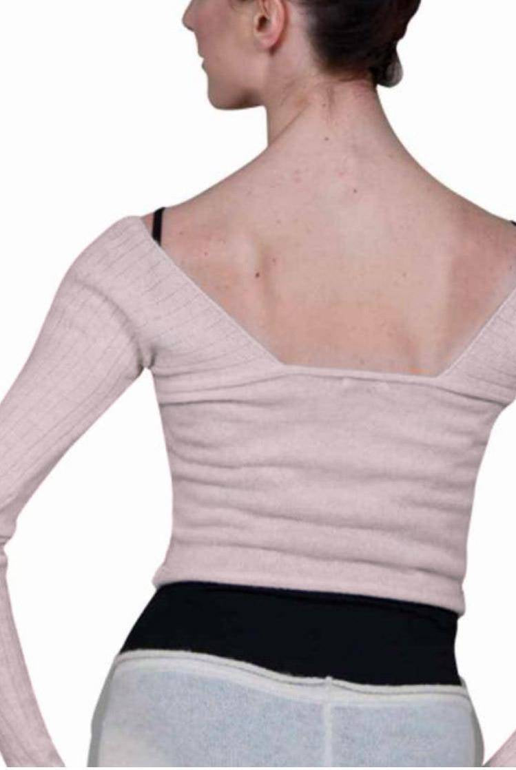 Eine Person, die mit dem Rücken zur Kamera steht, trägt ein hellrosa, schulterfreies Oberteil – identifiziert als Wärmetop Sansha KT4035A Karissa von Sansha – mit langen Ärmeln und schwarzen Trägern darunter. Ihre Haare sind ordentlich hochgesteckt und sie trägt auch enge Hosen. Der Hintergrund ist schlicht weiß.