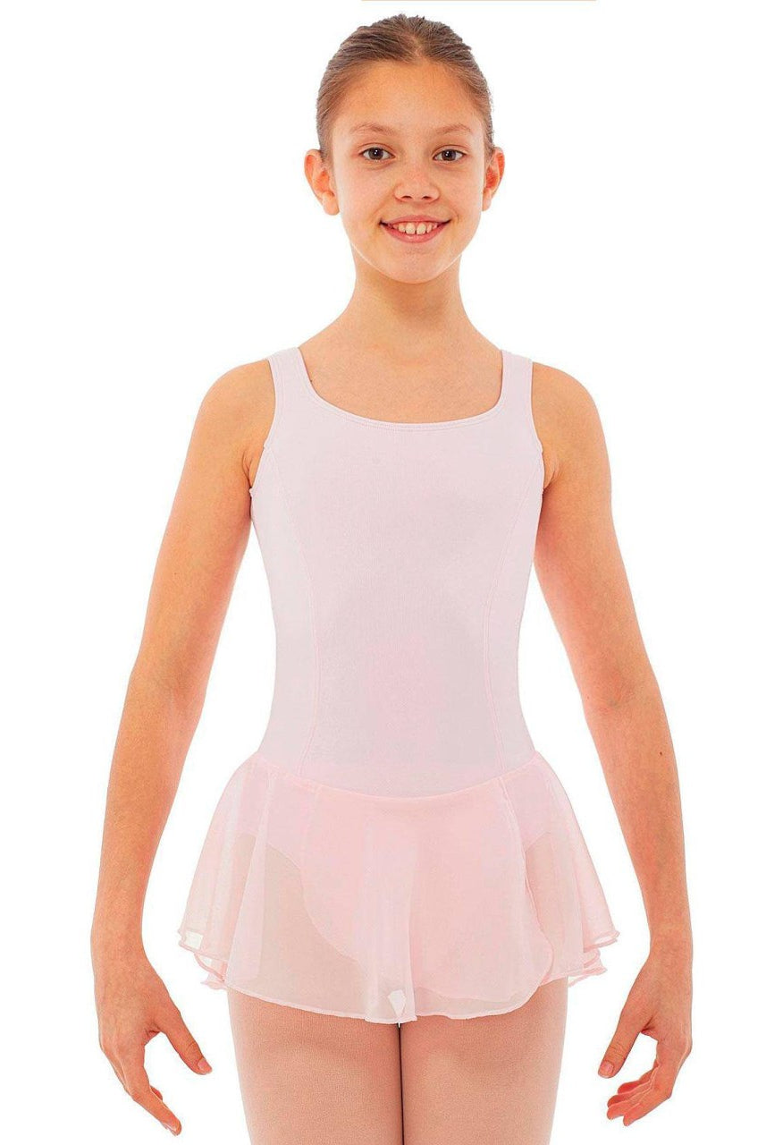 Ein junges Mädchen in einem Intermezzo Kinder-Ballettanzug 3057 mit einem hellrosa Chiffonrock aus Georgette-Stoff steht lächelnd da und hat die Arme leicht seitlich ausgestreckt. Sie hat ihr Haar ordentlich zurückgekämmt und der Hintergrund ist schlicht weiß.