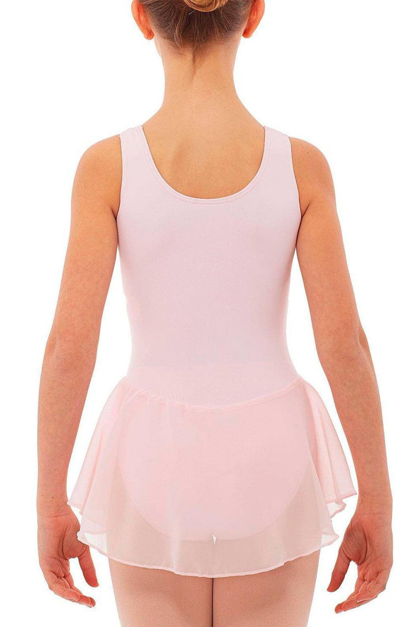 Ein junges Mädchen trägt einen hellrosa Intermezzo Kinder-Ballettanzug 3057 mit einem angenähten Rock aus Georgette-Stoff, von hinten gesehen. Ihr Haar ist ordentlich zu einem Knoten frisiert und ihre Arme hängen entspannt an den Seiten. Der schnelltrocknende Stoff sorgt dafür, dass sie sich während ihrer gesamten Tanzübung wohl fühlt.