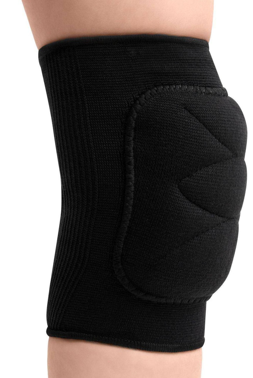 Eine Nahaufnahme des Knies einer Person, die einen schwarz gepolsterten Knieschoner Rumpf 215 von Rumpf trägt. Die Schiene bedeckt das Knie und bietet mit sichtbaren Nähten und einem strukturierten Design Halt und Schutz. Der umliegende Bereich ist unscharf und hebt die raffinierte schwarze Knieschiene hervor.