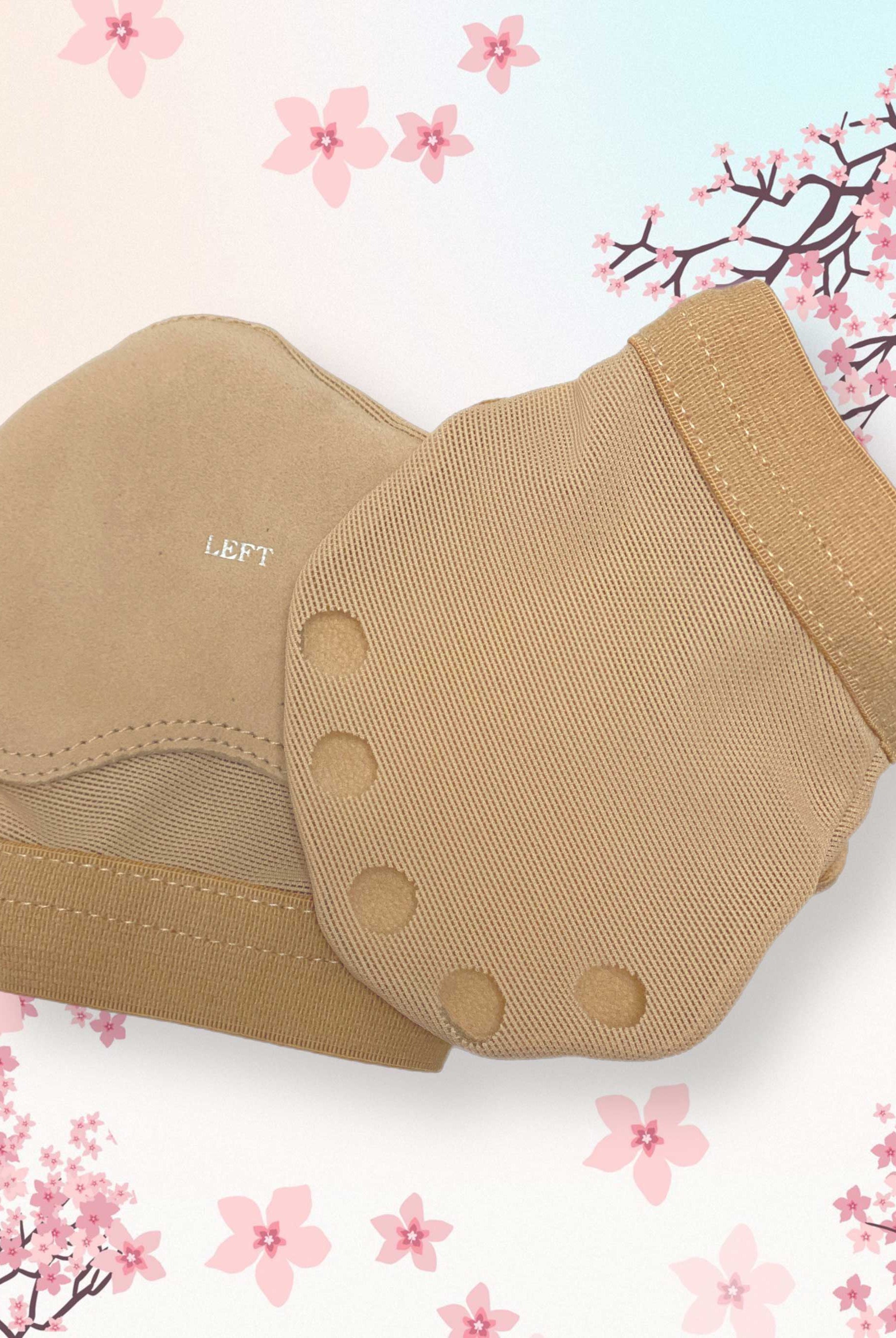 Ein Paar beigefarbene Ballenschutz Bloch S0660L Fußhandschuhe von Bloch mit Fußgewölbeunterstützung ist vor einem Hintergrund mit Kirschblütenillustrationen abgebildet. Die linke Socke trägt die Aufschrift „LINKS“ und beide Socken verfügen über strukturierte Bereiche und gerippte Öffnungen für besseren Halt und Komfort.
