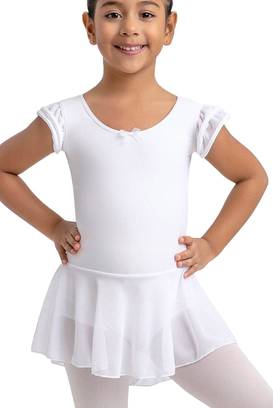 Ein kleines Kind lächelt, während es den Kinder-Ballettanzug Capezio 11882C Puff Sleeve trägt, ein weißes Ballett-Outfit von Capezio mit einem kurzärmeligen Trikot und einem transparenten Rock.