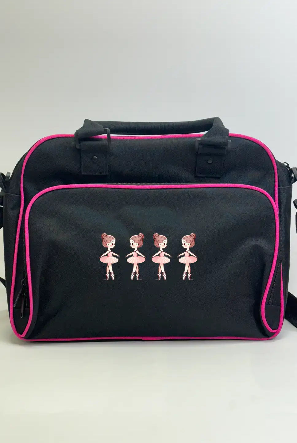 Die Danceline Kinder Balletttasche ist eine schwarze Umhängetasche mit rosa Paspelierung und einem gestickten Design von vier Ballerinas in rosa Kleidern auf der Vordertasche.