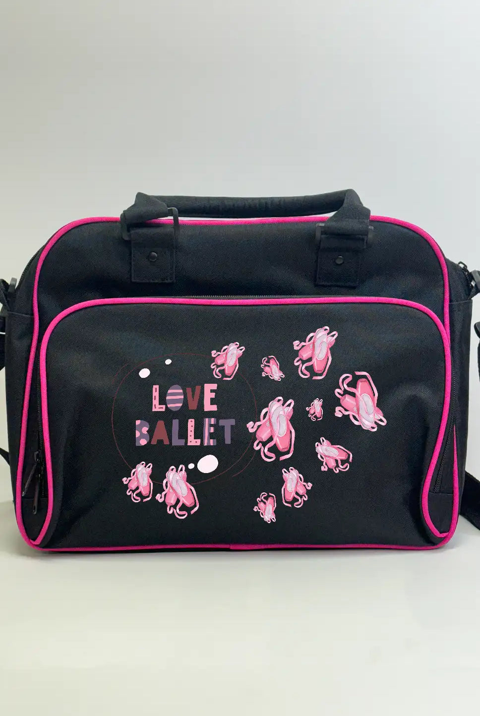 Die Kinder Balletttasche von Danceline hat ein elegantes schwarzes Design mit rosa Rand, verziert mit dem Spruch „Love Ballet“ und bezaubernden Illustrationen von rosa Ballettschuhen auf der Vordertasche. Sie ist mit Griffen und einem Schultergurt ausgestattet und bietet so vielseitige Tragemöglichkeiten.