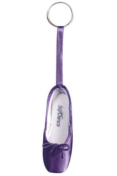 Ein Schlüsselanhänger mit einem Miniatur-Ballettschuh. Der Mini-Spitzenschuh-Anhänger SoDanca KCE01 Minipoint ist lila mit einer kleinen Schleife auf der Vorderseite und einer Schleife aus passendem Band, die ihn mit dem Schlüsselanhänger verbindet. Auf der Innenseite dieses bezaubernden Geschenks ist der Markenname „SoDanca“ in Grau aufgedruckt.