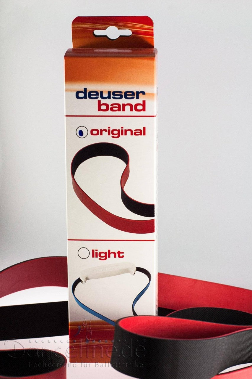 In einem weiß-roten Karton mit der Aufschrift „Zubehör SchmidSports 116000 Deuserband“ sind zwei Widerstandsbänder, ein schwarzes und ein rotes, ausgestellt. Die Abschnitte „Original“ mit schwarzem Band und „Light“ mit rotem Band zielen auf unterschiedliche Trainingsbedürfnisse ab. Daneben liegt ein Spiralwiderstandsband SchmidSports Deuserband, das sich perfekt für Dehnen-Übungen eignet.