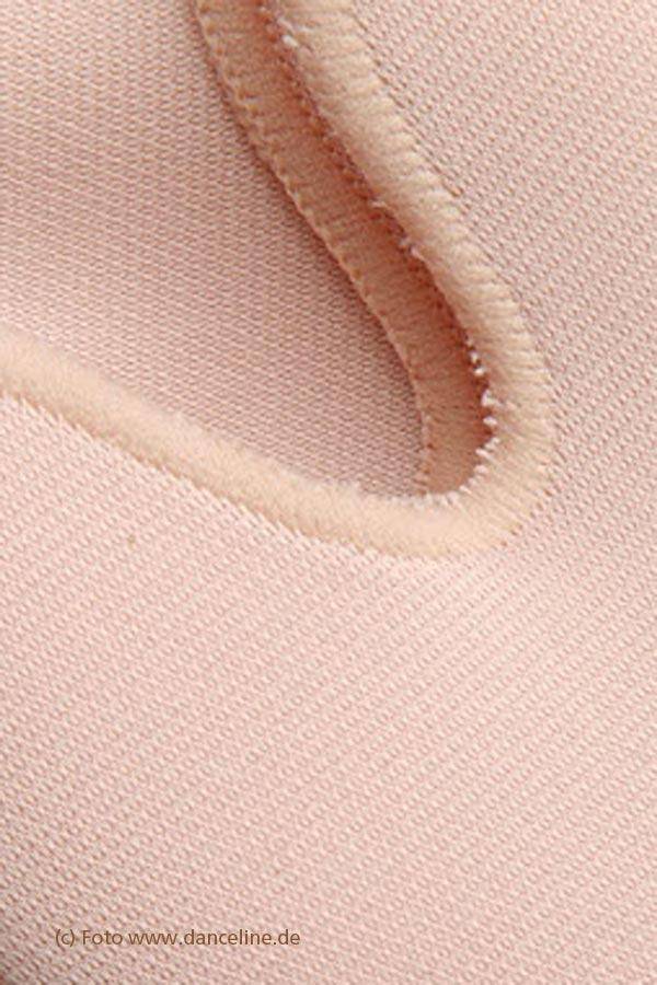 Nahaufnahme eines weichen, hellrosa Stoffes mit einer genähten Naht und einem geschwungenen Ausschnitt, der an die Materialien erinnert, die im Zehenpolster Bunhead BH1095 OuchPouchJunior von Dance Line verwendet werden. Die Textur wirkt leicht unscharf, wobei Schatten die Tiefe der Nähte hervorheben. Der Text unten lautet „(c) Foto www.danceline.de“.