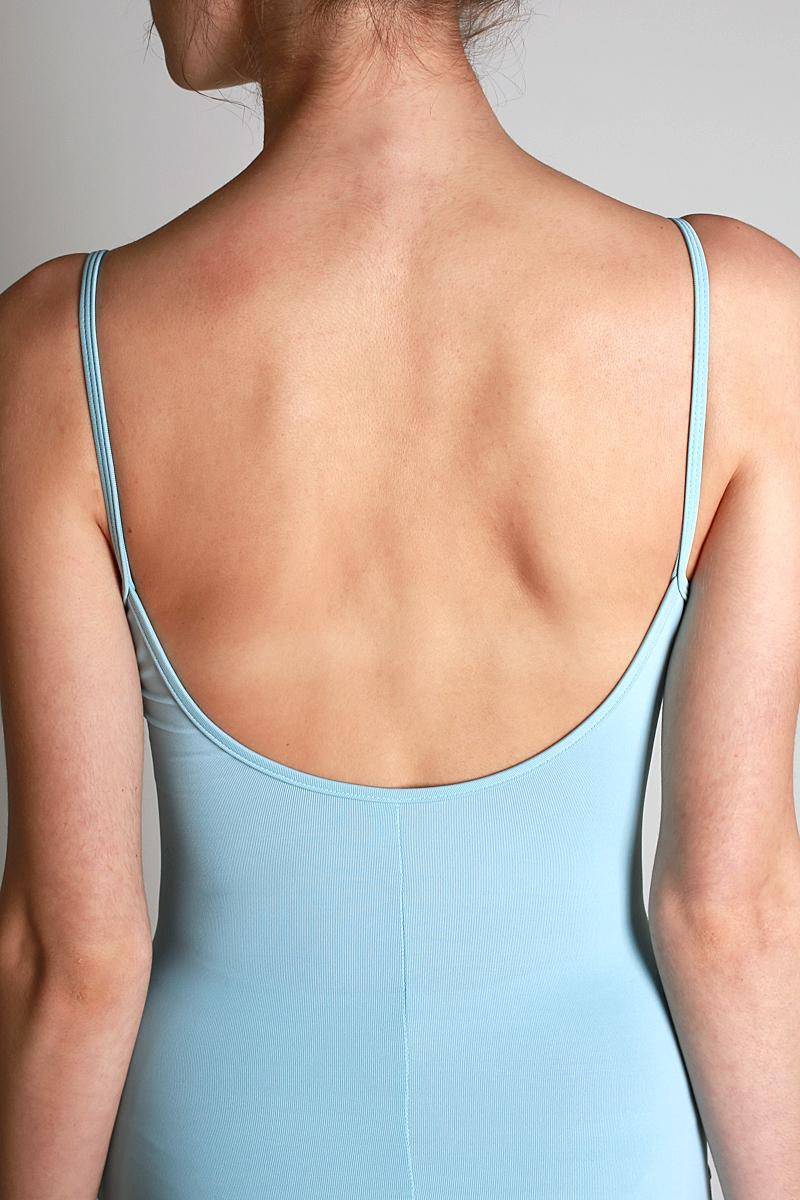 Eine Person, die mit dem Rücken zur Kamera steht und einen hellblauen Ballettanzug Bloch L5607 Nejor trägt. Die Haare sind hochgesteckt und die Haut ist sanft beleuchtet, wodurch die glatte Textur und die natürlichen Konturen des Rückens hervorgehoben werden.