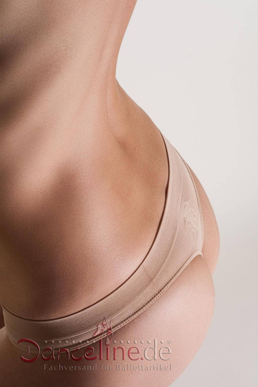 Eine Nahaufnahme zeigt den unteren Rücken und das Gesäß einer Person, die helle Tanga Capezio 3678 Kaya-Unterwäsche von Capezio trägt. Der weiße Hintergrund betont die sanften Kurven und den Hautton. Der deutsche Text am unteren Bildrand lautet: „Danceline.de Fachversand für Ballettartikel.