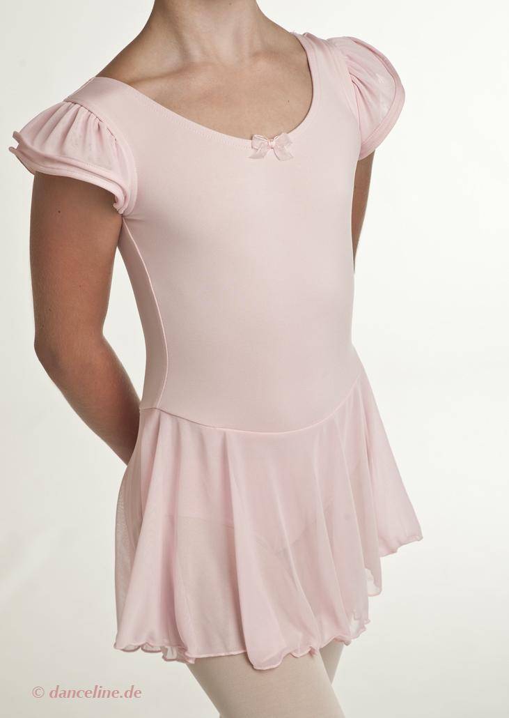 Eine Person trägt einen blassrosa Kinder-Ballettanzug Capezio 11882C Puff Sleeve von Capezio mit einer kleinen Schleife am Ausschnitt und einem angenähten Rock. Das zum Tanzen entworfene Outfit ist vor einem schlichten weißen Hintergrund fotografiert, wobei das Gesicht der Person nicht sichtbar ist.