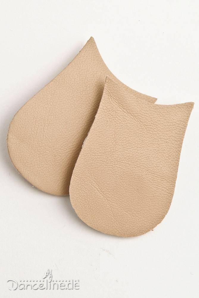 Zwei beige Lederflecken SoDanca LF Klava Tanzfußpolster liegen auf einer weißen Fläche. Die Polster sind tropfenförmig und haben an den Rändern eine Naht. In der unteren linken Ecke ist das Logo „SoDanca.de“ zu sehen, das an die Eleganz von Spitzenschuhen erinnert.
