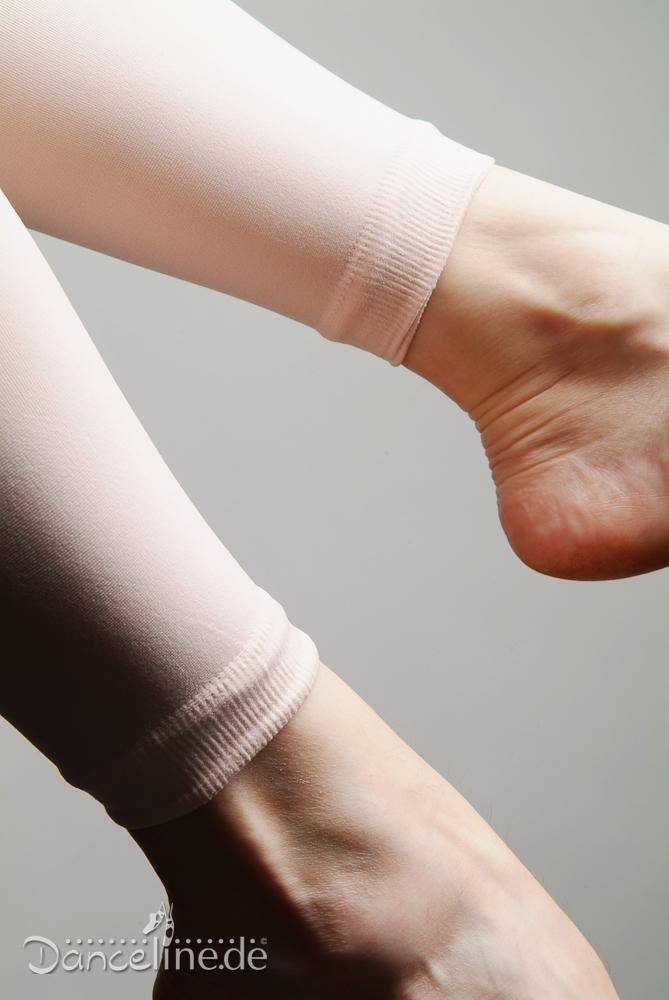 Nahaufnahme von zwei Füßen, die vor einem neutralen Hintergrund eine blassrosa Ballettstrumpfhose Rumpf 106 Sans tragen. Das Bild zeigt die Textur und Passform der sehr dehnbaren Strumpfhose um die Knöchel. Das Logo „Danceline.de“ ist in der unteren linken Ecke sichtbar.