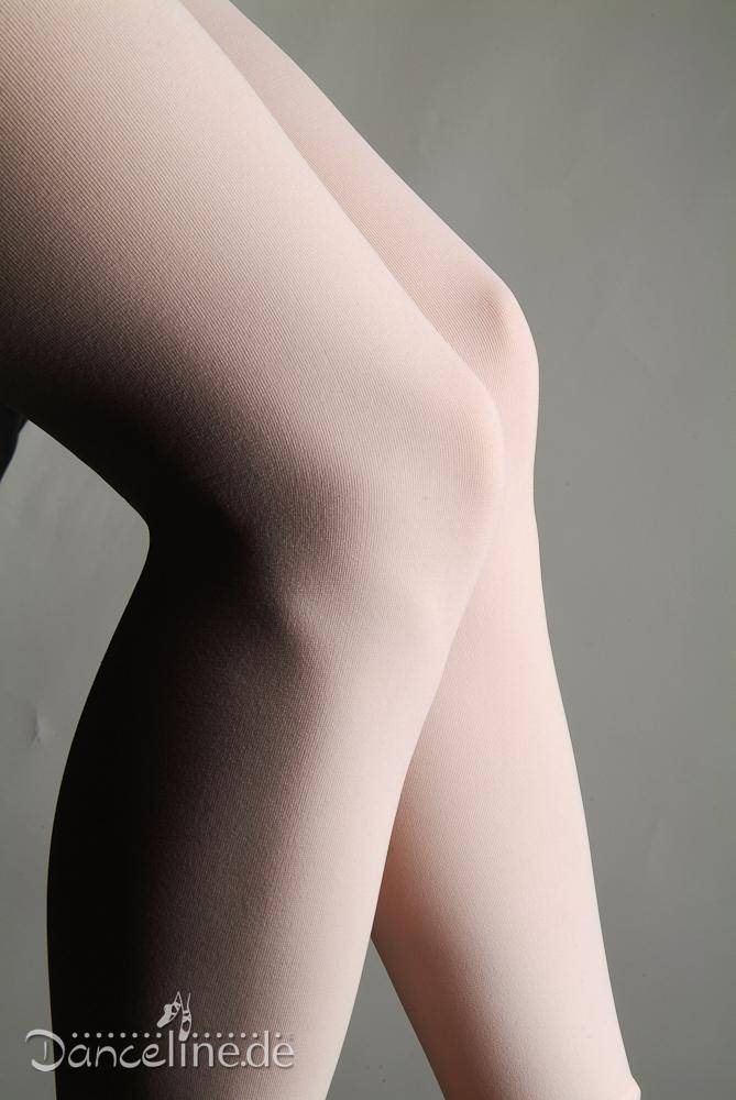 Nahaufnahme von übereinandergeschlagenen Beinen in einer blassrosa Ballettstrumpfhose Rumpf 106 Sans vor einem einfarbigen Hintergrund. Die Textur des Stoffes ist glatt und leicht glänzend, wobei der nahtlose Eindruck betont wird. In der unteren linken Ecke ist das Wort „Danceline.de“ zu sehen.