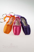 Drei Mini-Spitzenschuh-Anhänger SoDanca KCE01 Minipoints sind in Orange, Pink und Lila erhältlich. Jeder Schlüsselanhänger hat eine glänzende Satinoberfläche und ist nebeneinander auf einer weißen Oberfläche angeordnet, mit einem „Danceline.de“-Logo an der Unterseite – ein elegantes Geschenk für jeden Tanzbegeisterten.