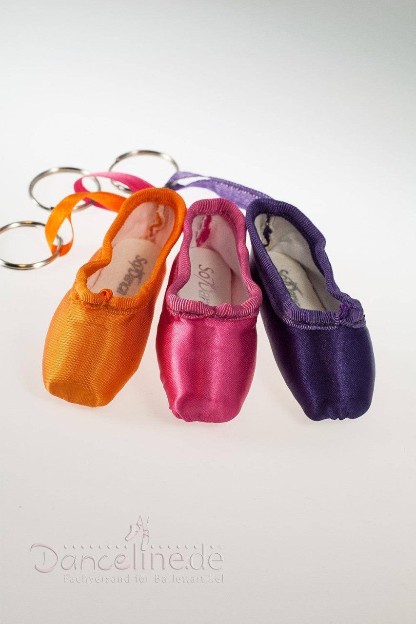 Drei Mini-Spitzenschuh-Anhänger SoDanca KCE01 Minipoints sind in Orange, Pink und Lila erhältlich. Jeder Schlüsselanhänger hat eine glänzende Satinoberfläche und ist nebeneinander auf einer weißen Oberfläche angeordnet, mit einem „Danceline.de“-Logo an der Unterseite – ein elegantes Geschenk für jeden Tanzbegeisterten.