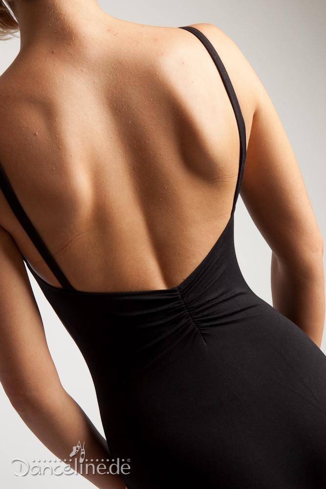 Nahaufnahme eines Frauenrückens in einem schwarzen, ärmellosen Ballettanzug mit V-Rücken aus glattem, schnelltrocknendem Material von Danceries T16SU Linda SU. Ihre glatte Haut kontrastiert mit den dünnen Schulterträgern des Damenobertrikots von Danceries. Der neutrale Hintergrund ist leicht beleuchtet und das Danceline.de-Logo ist in der unteren linken Ecke sichtbar.