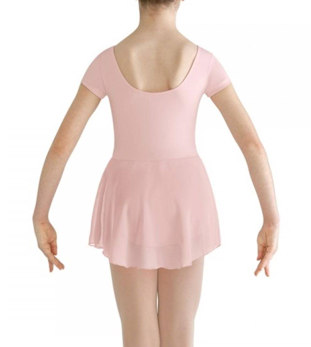 Eine junge Person ist von hinten abgebildet und trägt den Bloch Kinder Ballettanzug CL8262 Prisha in Hellrosa. Das Outfit besteht aus einem Turnanzug mit Flügelärmeln und U-Ausschnitt sowie einem transparenten Georgette-Rock. Die Person steht vor einem schlichten weißen Hintergrund mit leicht ausgestreckten Armen an den Seiten.