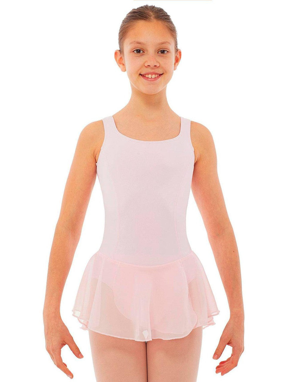 Ein junges Mädchen in einem Intermezzo Kinder-Ballettanzug 3057 mit einem hellrosa Chiffonrock aus Georgette-Stoff steht lächelnd da und hat die Arme leicht seitlich ausgestreckt. Sie hat ihr Haar ordentlich zurückgekämmt und der Hintergrund ist schlicht weiß.