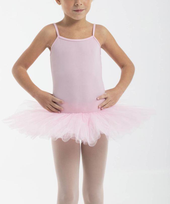 Ein junges Mädchen trägt das Tutu Intermezzo 3152 von Intermezzo, einen hellrosa Ballettanzug mit Spaghettiträgern und einem dazu passenden Basic-Tutu aus vier Lagen Tüll. Ihre Hände sind auf ihren Hüften abgelegt und sie steht vor einem schlichten weißen Hintergrund.