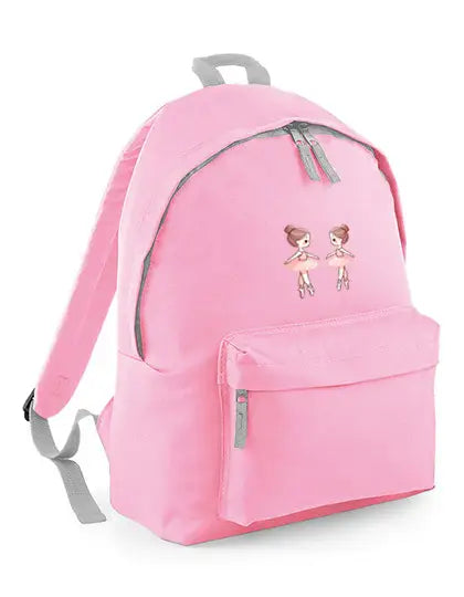 Der Kinder-Ballettrucksack Miniballerinas von Dance Line ist ein rosa Rucksack mit zwei kleinen gestickten Ballerina-Motiven auf der Vordertasche. Er verfügt über ein großes Hauptfach, eine Reißverschlusstasche vorne und verstellbare graue Schultergurte.