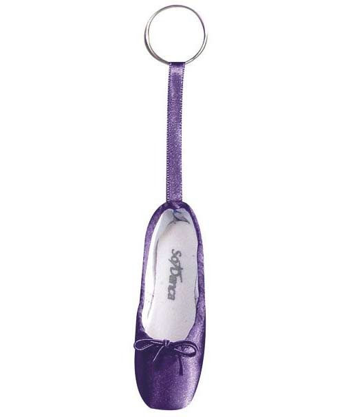 Ein Schlüsselanhänger mit einem Miniatur-Ballettschuh. Der Mini-Spitzenschuh-Anhänger SoDanca KCE01 Minipoint ist lila mit einer kleinen Schleife auf der Vorderseite und einer Schleife aus passendem Band, die ihn mit dem Schlüsselanhänger verbindet. Auf der Innenseite dieses bezaubernden Geschenks ist der Markenname „SoDanca“ in Grau aufgedruckt.
